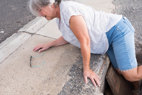 High Angle View Of Senior Woman Fallen Down On Footpath stock photo