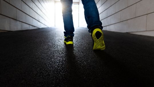 Man walking through a dark tunnel