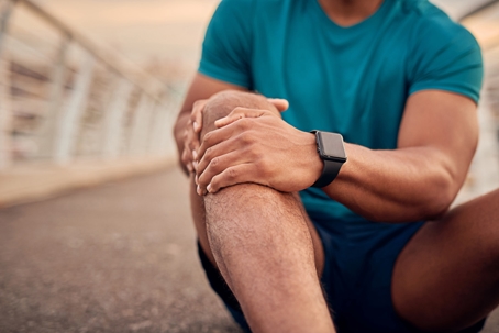 man with a muscle sprain in the knee from workout