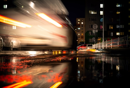 A white car on the road with a blurred traffic background
