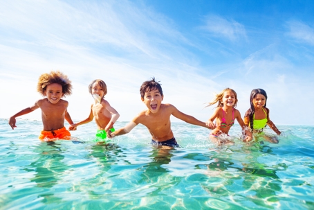 Kids laughing and playing in water at the seaside stock photo