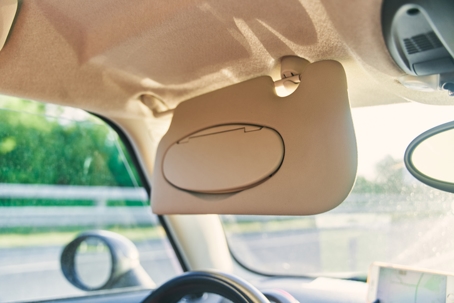Grey open sun visor in car interior stock photo
