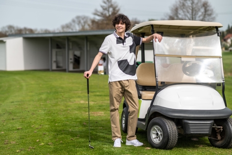Dark-haired caucasian young golfer with a brassie in hand stock photo
