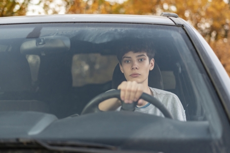 Young teenager learns how to drive the car