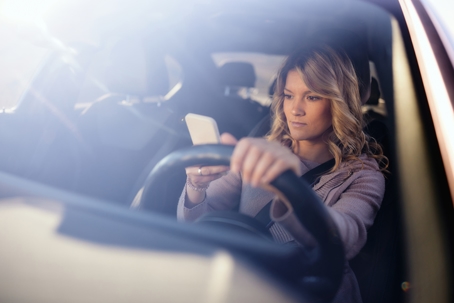 Careless woman using cell phone while driving a car. stock photo