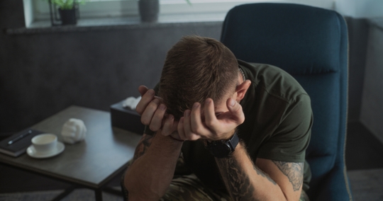 Portrait of military man with PTSD crying during psychotherapy session stock photo