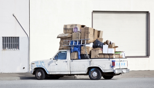 white pick up truck overpacked on the road