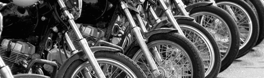 Seven black motorcycles in a row