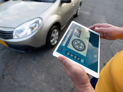 Unrecognizable mechanic using tablet to check pressure of vehicle wheels stock photo