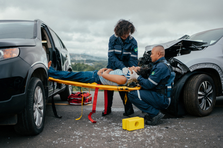 Paramedics placing injured woman who suffered a car accident onto a rigid stretcher. stock photo