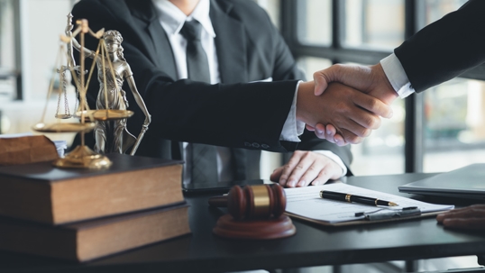 Lawyer and client shake hands, after winning a lawsuit where a lawyer hired by a client in a fraud case and proceeding in a fair and correct manner, the client wins the case. Fraud litigation concept.