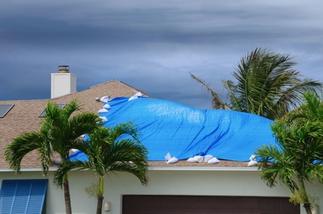 property damage and blue tarp on the roof of a house
